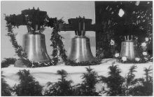 Abbildung der Glocken in Schwarzweiß und noch nicht im Kirchturminstalliert. AUfgereiht auf einem geschmücktem Tisch.