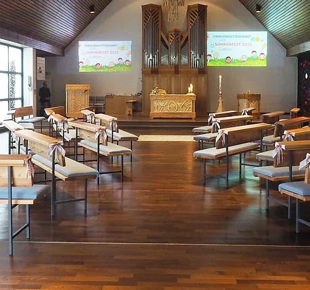 Bild der Erlöserkirche von innen. Im Vordergrund sind die alten Kirchbänke zu sehen. Im Hintergrund sind in der Mitte Altar Orgel und Kreuz zu sehen. Rechts hinten das Taufbecken und links hinten die Kanzel.